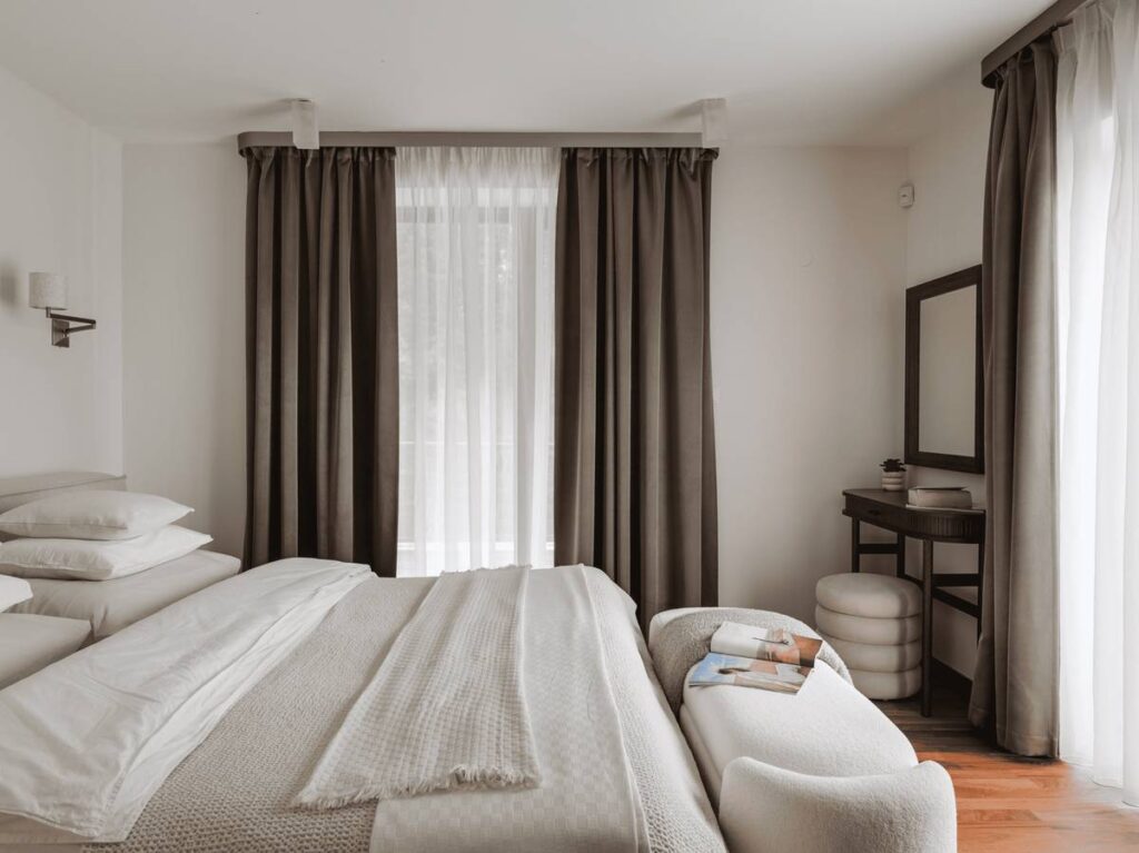 Moderní ložnice s neutrálním dekorem a velkým oknem